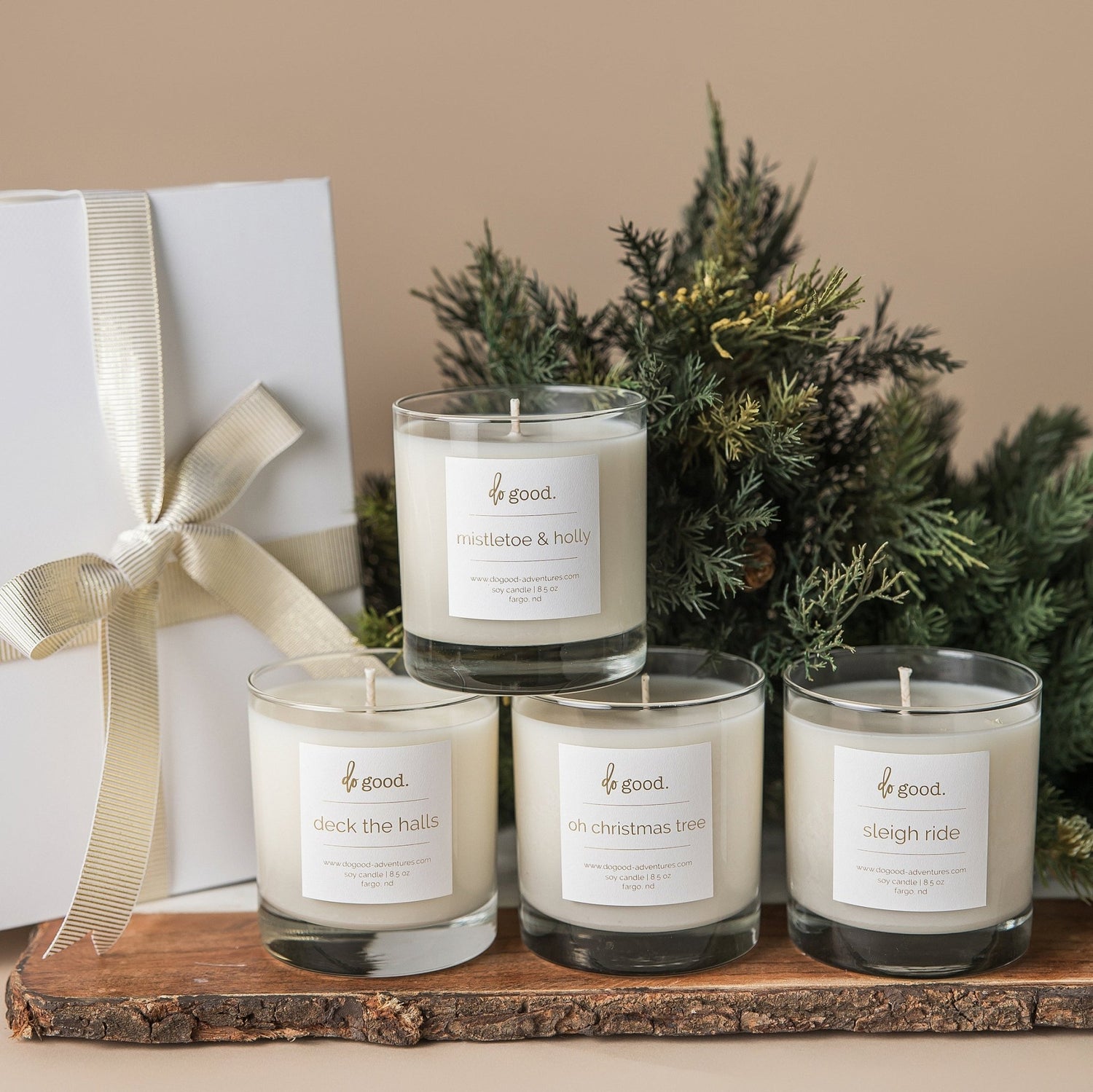 Image of four soy candles in the holiday collection: deck the halls, mistletoe & holly, oh christmas tree, and sleigh ride