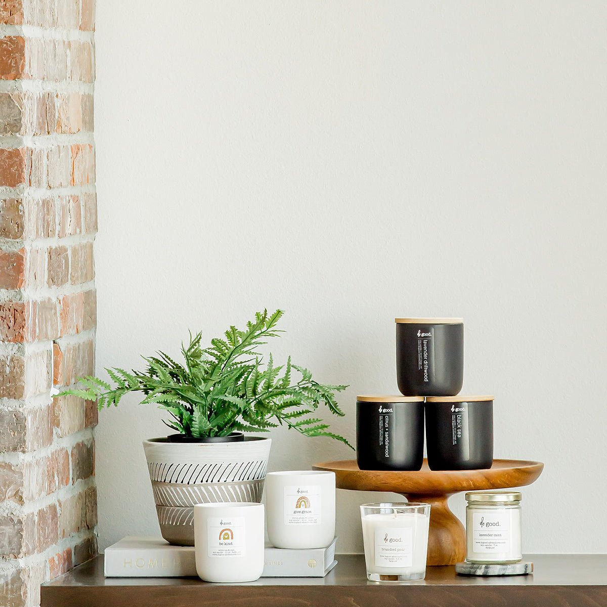 Image of various candle styles and collections styled together on a shelf