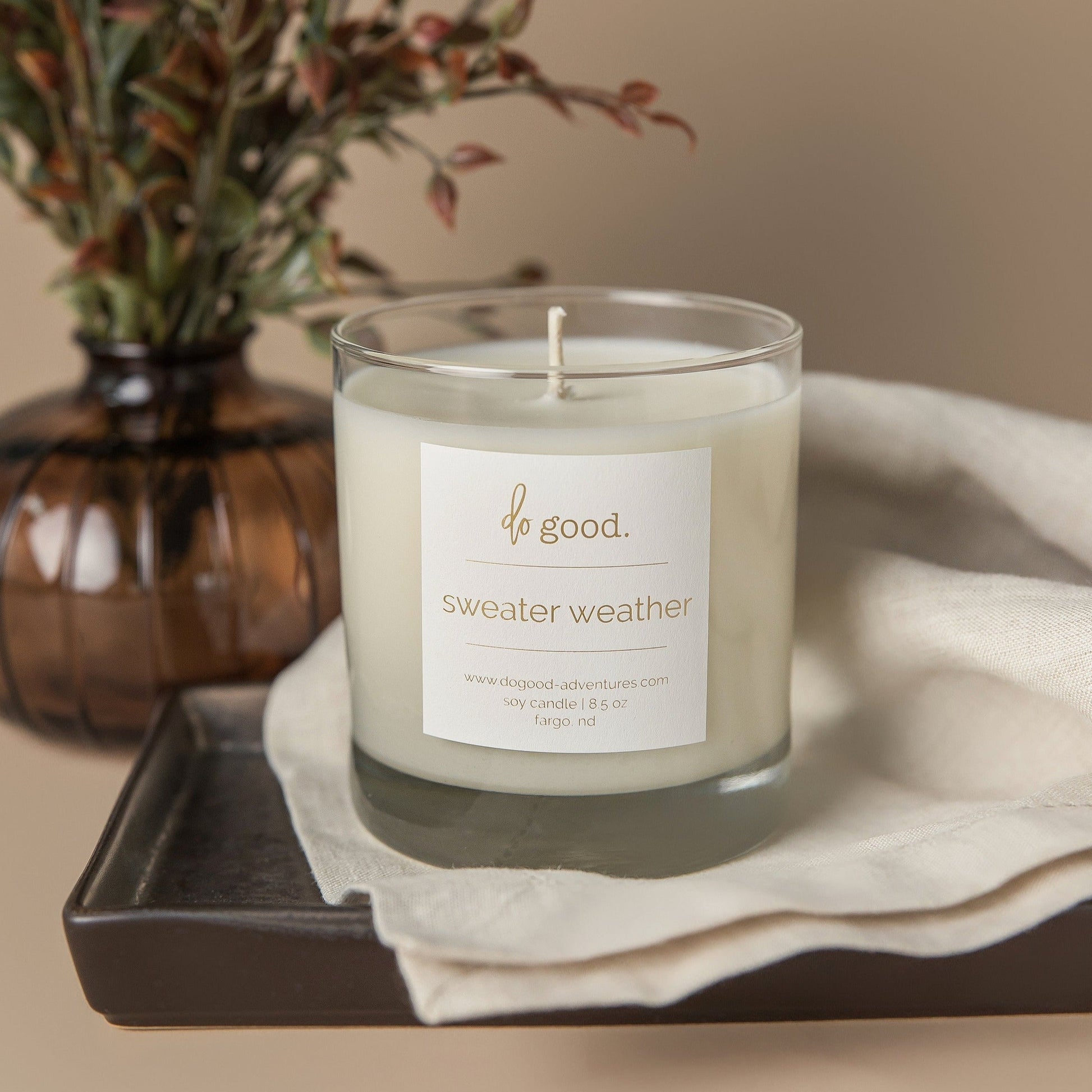 image of 8.5 ounce soy candle scented with notes of peppercorn, citrus and other spices that is named "sweater weather"