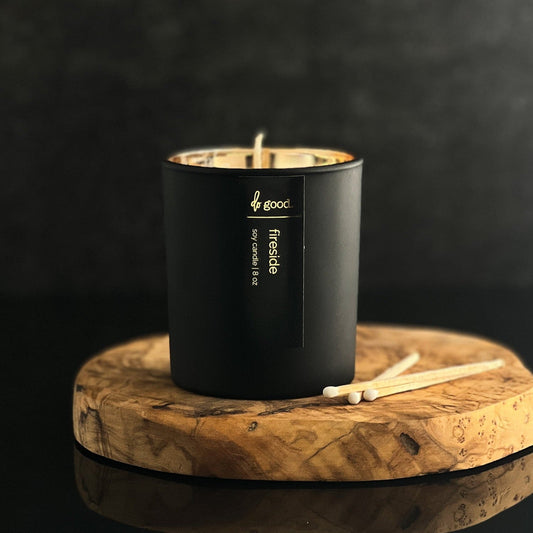 This is a photo of a soy candle named fireside poured in a matte black vessel with a gold electroplated interior