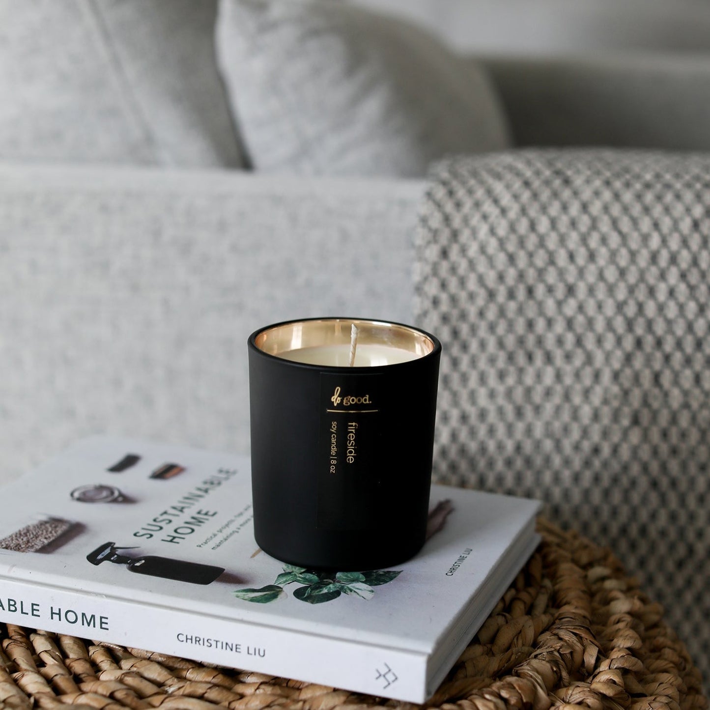 picture of soy candle named fireside in a living room sitting on top of a side table and book next to a chair