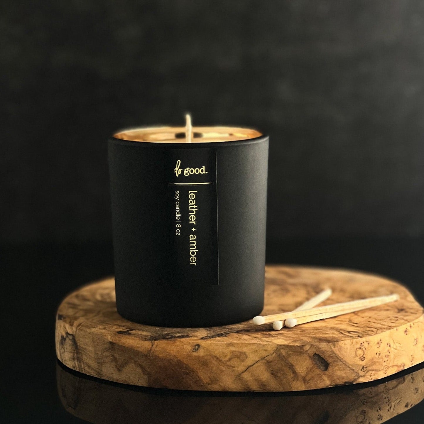 leather and amber soy candle in a matte black vessel with electroplated interior