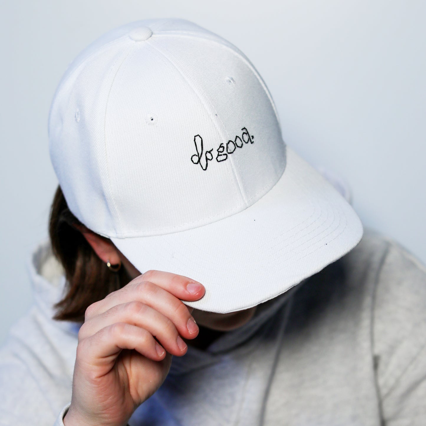 white baseball cap with hand-embroidered do good