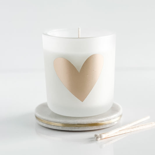 This stunning candle is the perfect combination of earthy notes sandalwood and cedar, blended with warm, cozy, soothing notes of creamy shea.  To make it even better, it is topped off with luxurious notes of cashmere (think lavender, powder, and vanilla).  This is an elegant, soothing fragrance that is not too feminine and perfect year-round.    This gorgeous 8.5-ounce soy candle is currently available in this beautiful frosted white tumbler adorned with a matte gold heart.  